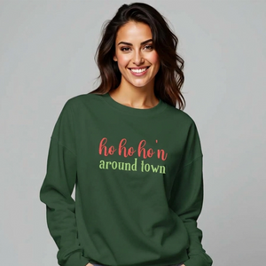  Woman wearing a green sweatshirt that reads ho ho ho'n around town in red and green text.