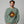 Man wearing a green sweatshirt with a graphic design on a gray background