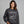 Woman wearing a dark gray sweatshirt with motorcycle graphic and text on a gray background