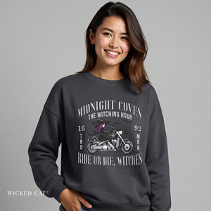 Woman wearing a dark gray sweatshirt with motorcycle graphic and text on a gray background