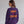 A woman shown from the back wearing a purple crewneck sweatshirt with 'SHAKE THE STADIUM' printed in orange and red across the back. The brand name 'WICKED CAT' is visible in the bottom-left corner.