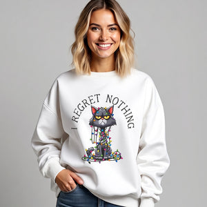 Woman wearing a white sweatshirt with a graphic of a cat tangled in Christmas lights and text the says 'I Regret Nothing'.