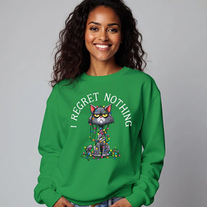 woman wearing green sweatshirt with a graphic of a cat tangled in Christmas lights and text the says 'I Regret Nothing'.