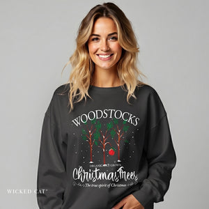 Woman wearing a black sweatshirt with 'Woodstocks Christmas Trees' design on a gray background