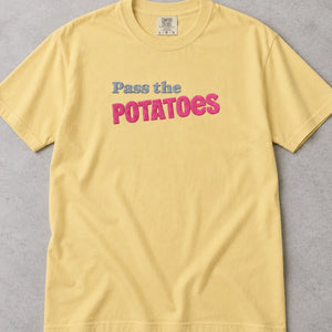 Yellow t-shirt with embroidered text that says Pass the Potatoes 