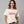woman wearing an ivory t-shirt with embroidered text that says Pass the Potatoes 