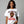 Woman wearing a white t-shirt with a turkey graphic and text, on a gray background