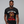 Man wearing a black t-shirt with a graphic of a turkey and text, on a plain background.