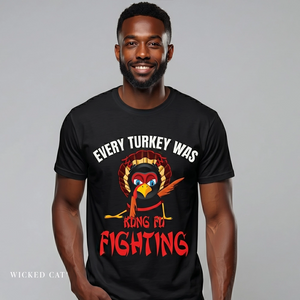 Man wearing a black t-shirt with a graphic of a turkey and text, on a plain background.