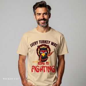 Man wearing a beige t-shirt with a graphic of a turkey and text on a gray background