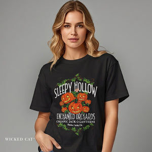 Woman wearing a black t-shirt with 'Sleepy Hollow Enchanted Orchards' design on a gray background