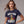 Woman wearing a navy blue t-shirt with 'WHO'S YOUR DADDY' July 4th graphic design on a plain background