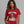 Woman wearing a red t-shirt with a graphic and text on a gray background