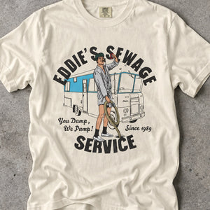 Ivory t-shirt with logo graphic and text 'Eddie's Sewage Service You Dump We Pump Since 1989'.