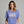 Woman wearing a blue t-shirt with 'IT NEEDS MORE POWER' text on a gray background