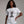 woman wearing white t-shirt with a cartoon cat tangled in Christmas lights with text at the top that says I Regret Nothing