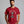 Man wearing a red t-shirt with a cartoon cat tangled in Christmas lights with text at the top that says I Regret Nothing
