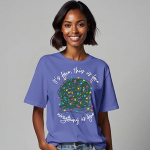 woman wearing purple t-shirt with a graphic of a tangled ball of lights with text It's fine, this is fine, everything is fine.