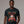 Man wearing a black t-shirt with a festive design of a woman in a Santa hat and reindeer.