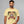 Man wearing a yellow t-shirt with a graphic design of a moonshine distillery label.