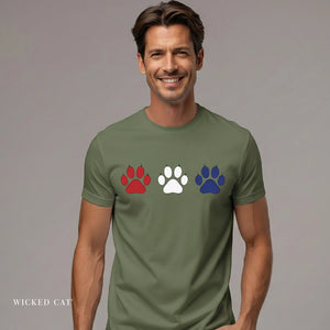 Man wearing a green t-shirt with colorful paw prints on a gray background
