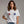Woman wearing a white t-shirt with paw print designs on a plain background