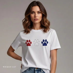 Woman wearing a white t-shirt with paw print designs on a plain background