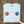 Light blue t-shirt with red, white, and blue paw prints on a wooden surface.