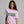 Woman wearing a light purple t-shirt with 'ELM ST.' printed on it against a gray background