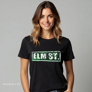 Woman wearing a black t-shirt with 'ELM ST.' printed on it against a gray background
