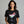 Woman wearing a black t-shirt with a Christmas-themed cocktail graphic on a gray background