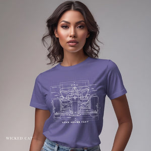 Woman wearing a purple t-shirt with a race car blueprint design and text on a gray background