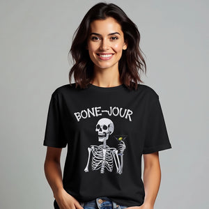 Woman wearing a black t-shirt with a graphic of a skeleton holding a martini with Bone-Jour in bone style lettering at the top.