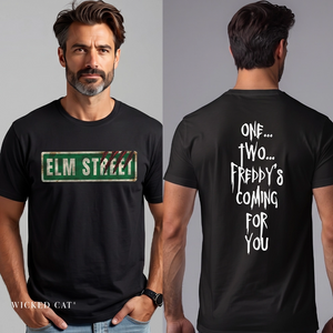 A man modeling a black graphic T-shirt shown from both front and back. The front has a green distressed street-sign style graphic reading 'ELM STREET.