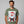 Man wearing a green t-shirt with a graphic of Santa Claus from a mugshot design on a gray background.