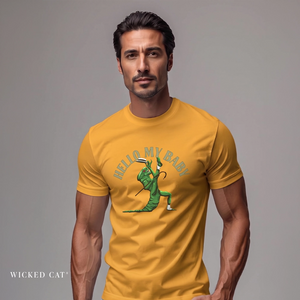 A man wearing a mustard yellow graphic t-shirt with a green cartoon alien and the text 'HELLO MY BABY' on the chest, set against a plain gray studio background.