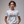 Woman wearing a white t-shirt with 'dare to DREAM' text on a plain background