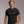 Man wearing a black t-shirt with 'Generation Fuck It' text against a plain background