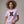 Woman wearing a light purple t-shirt with embroidered Gen X graphic design and text.