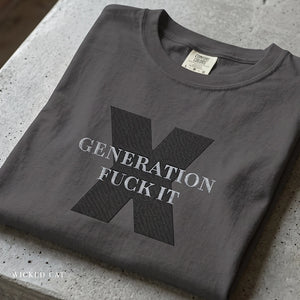 Folded dark gray t-shirt with graphic design and text on a concrete surface
