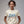 Woman wearing a white t-shirt with '250 YRS NO KINGS' text on a gray background