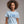 Woman wearing a light blue t-shirt with '250 Yrs No Kings' text on a plain background