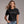 Woman wearing a black t-shirt with 'SIP SIP Hooray' text, standing against a plain background.