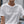 White t-shirt with 'SIP SIP HOORAY' text and a green leaf design on a blurred background