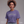 Woman wearing a purple t-shirt with text, standing against a plain background