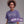 Woman wearing a purple t-shirt with 'WOOKIN' PA NUB' text, standing against a gray background.