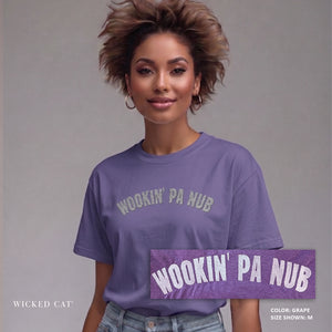 Woman wearing a purple t-shirt with 'WOOKIN' PA NUB' text, standing against a gray background.
