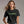 Woman wearing a black t-shirt with 'EWW, PEOPLE.' text in green on a plain background