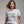 Woman wearing a white t-shirt with 'Eww, People' text in green on a gray background
