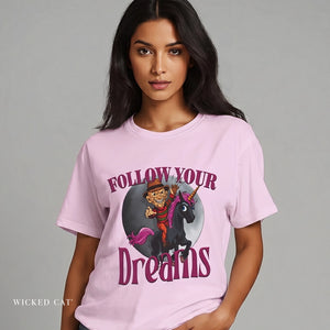 Woman wearing a pink t-shirt with a graphic design and text 'Follow Your Dreams' on a gray background.